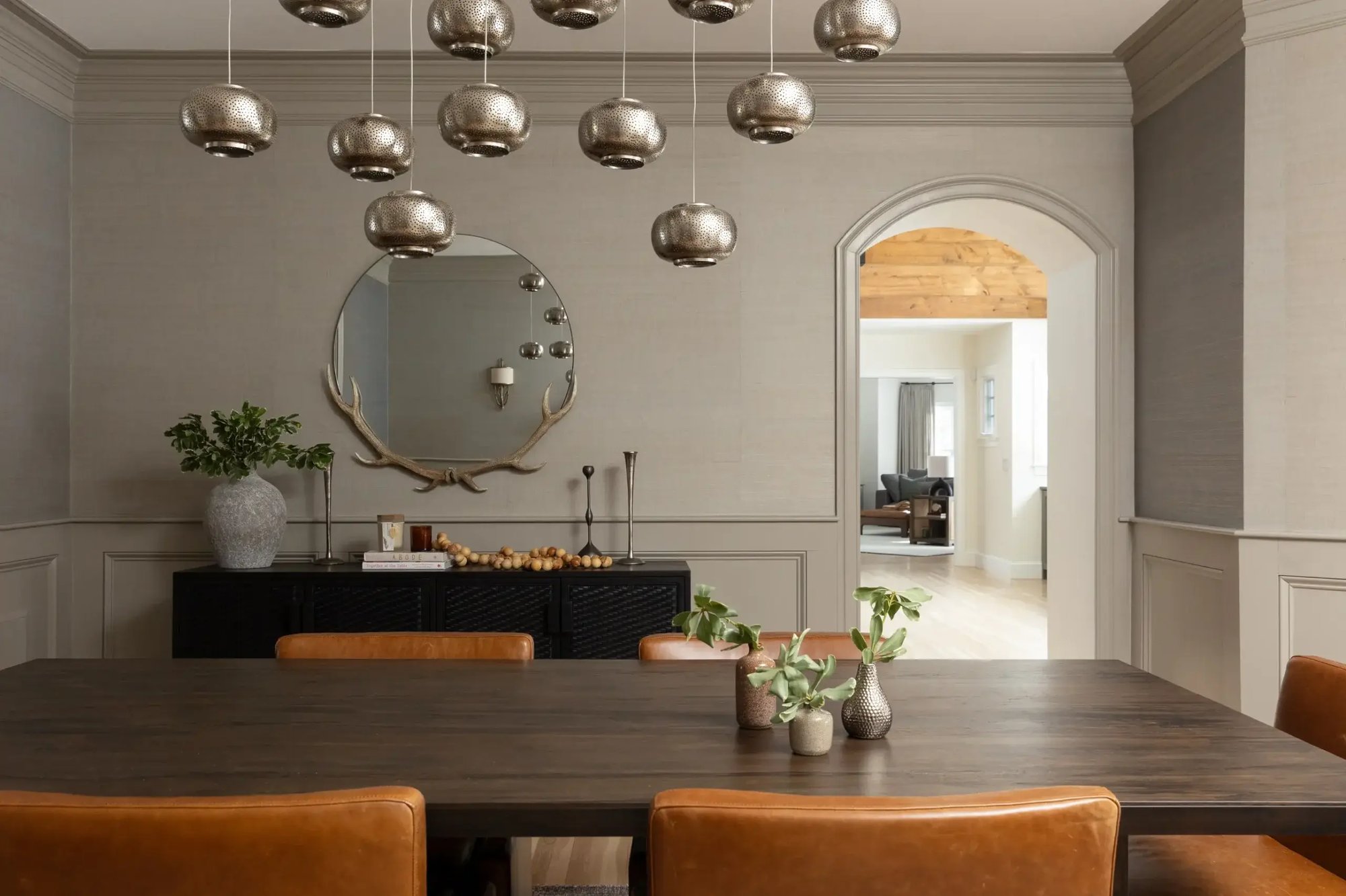 Dining room design in Boston with a dark wood table, leather chairs, and cascading silver pendant lights, designed by Lee Kimball. Dining room design in Boston with a dark wood table, leather chairs, and cascading silver pendant lights, designed by Lee Kimball.