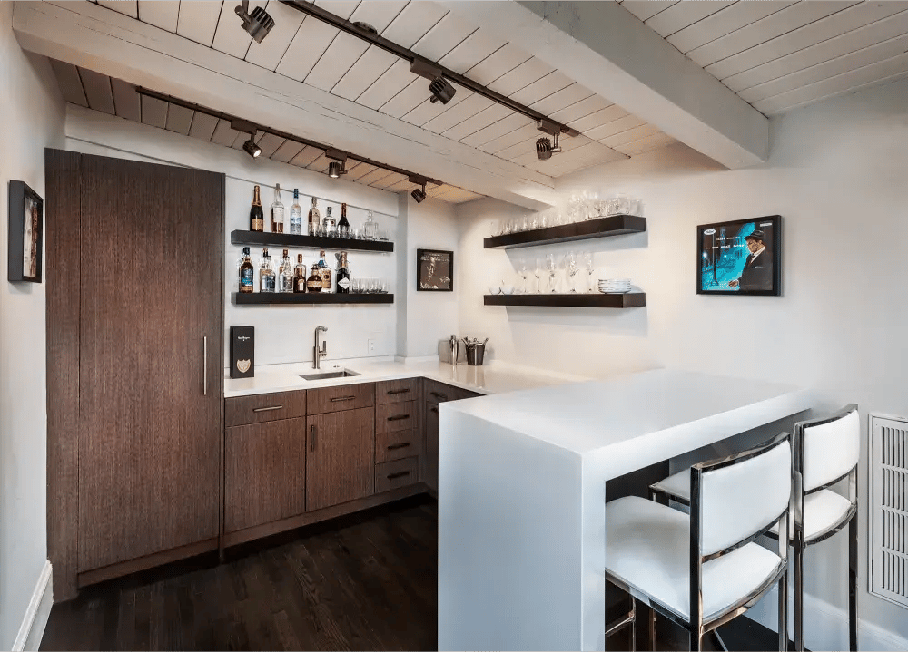 Modern home bar in Greater Boston with wood cabinets, open shelving, and sleek white bar seating