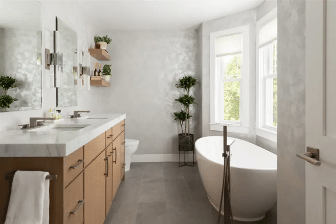 Bright bathroom with double vanity and freestanding tub in Greater Boston