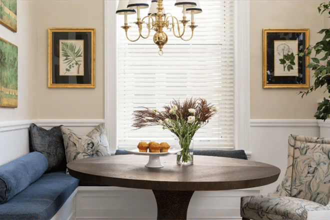 Charming breakfast nook in Greater Boston with round table, blue banquette seating, and brass chandelier