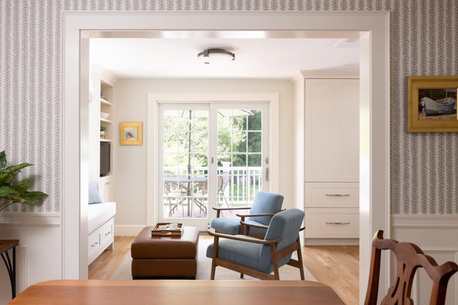 Cozy sitting room with blue chair and French doors to deck in Greater Boston