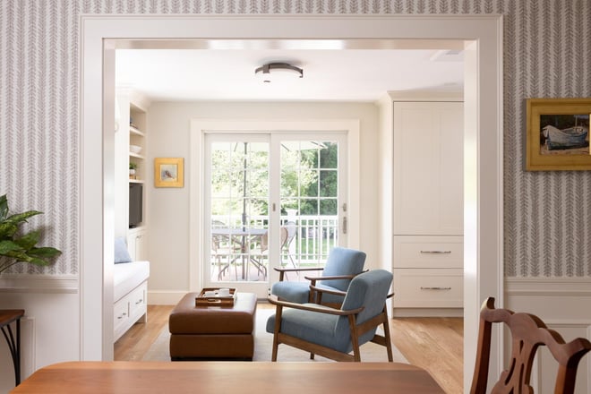 Cozy sitting room with blue chair and French doors to deck in Greater Boston