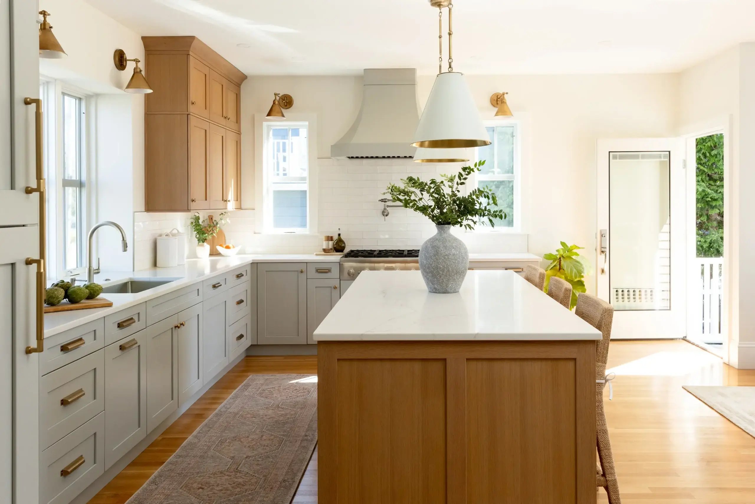 Light-filled kitchen with wood island and brass accents in Greater Boston