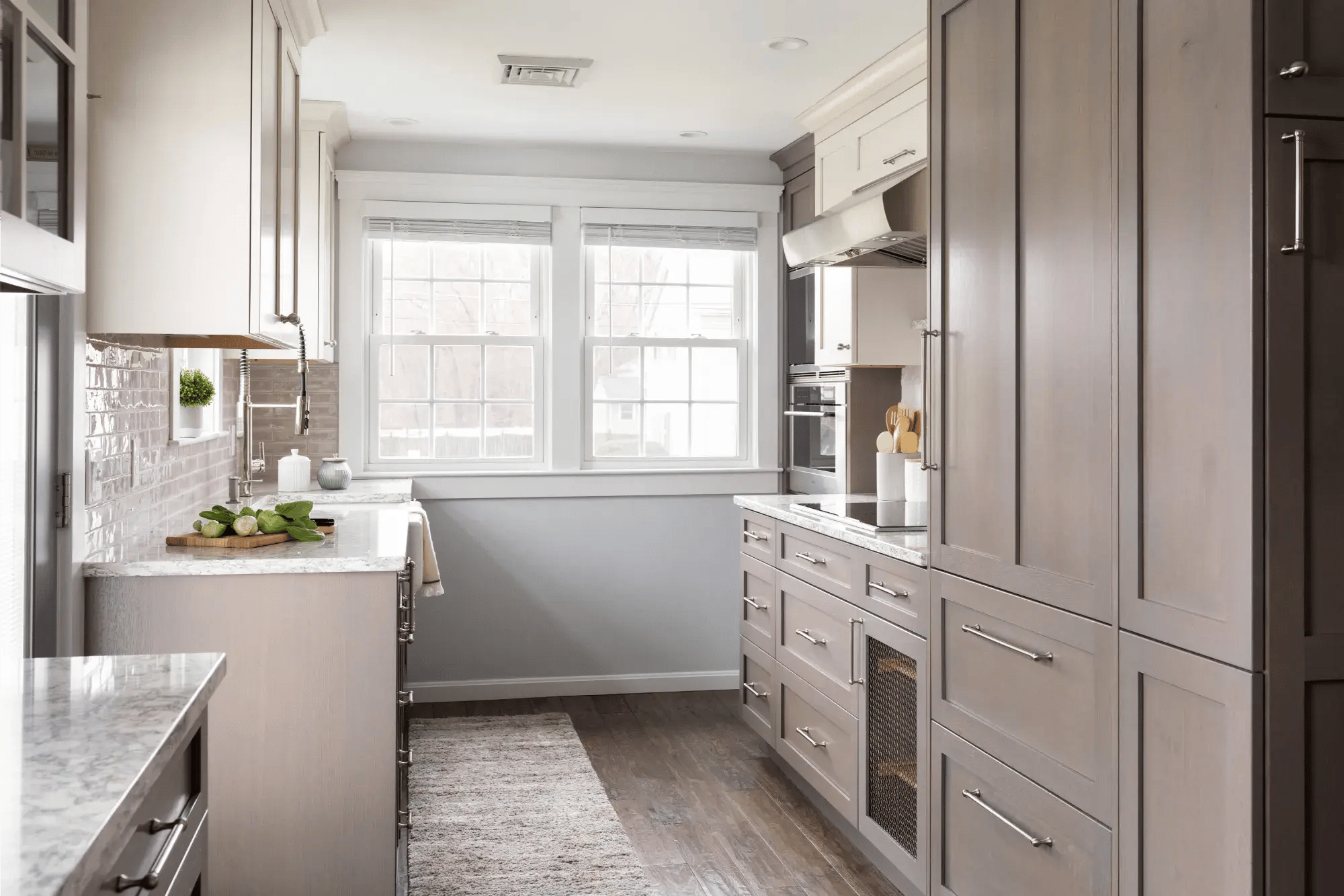 Narrow galley kitchen with gray cabinetry and marble counters in Greater Boston