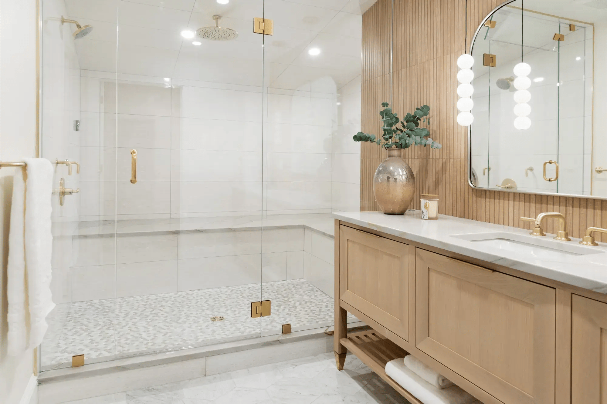 Luxurious walk-in shower and furniture-like double vanity with sculptural lighting and mirror in Boston