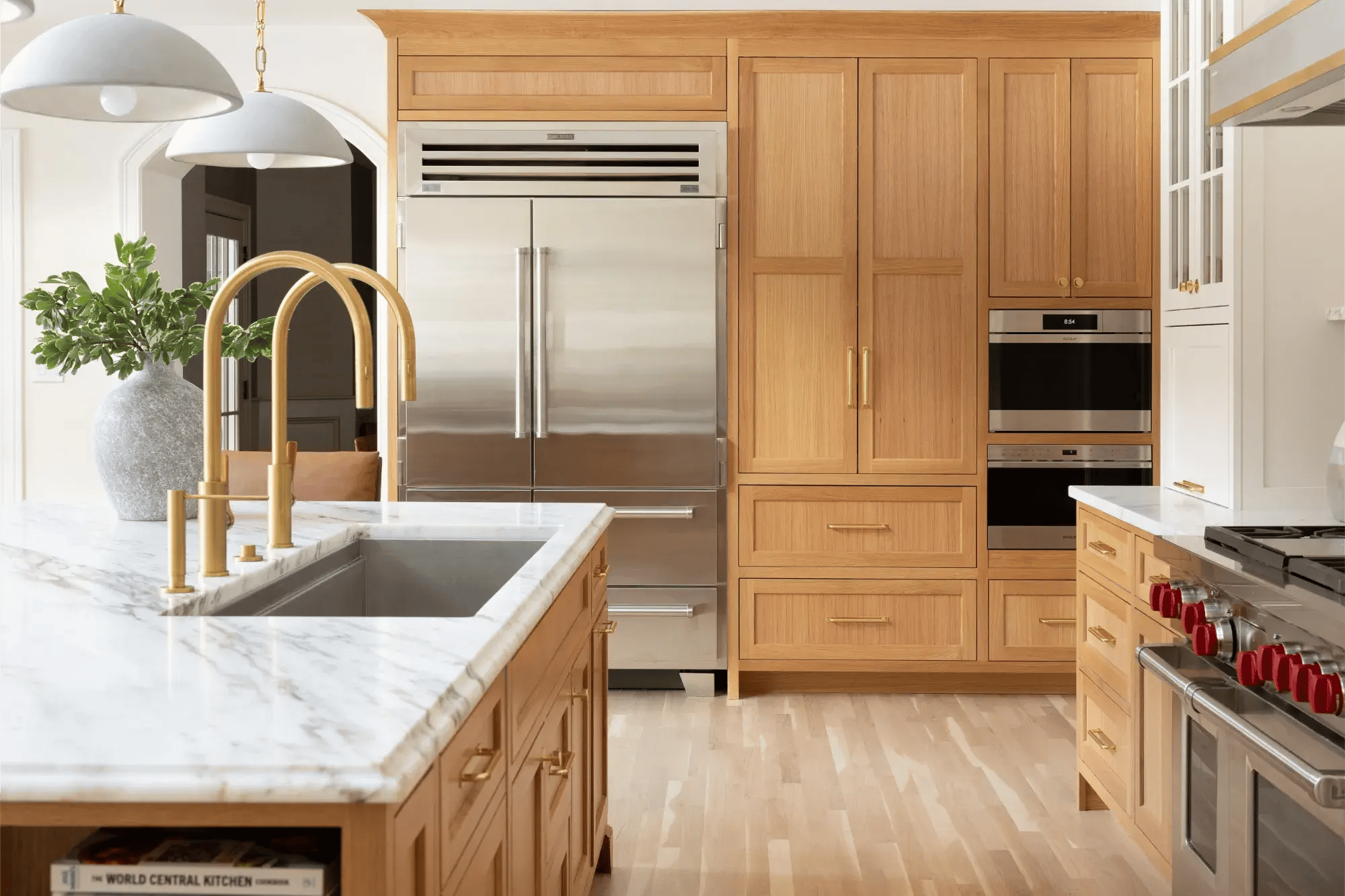 Spacious Home Renovation kitchen featuring built in appliances and warm wooden cabinetry