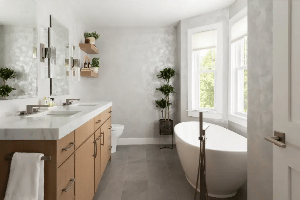 spa like bathroom in Boston with soaker tub and floor-fill faucet, double vanity, and textured walls