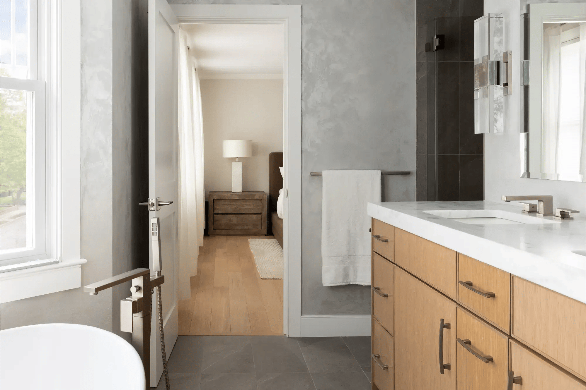 View from newly remodeled primary bath with soaker tub into bedroom beyond