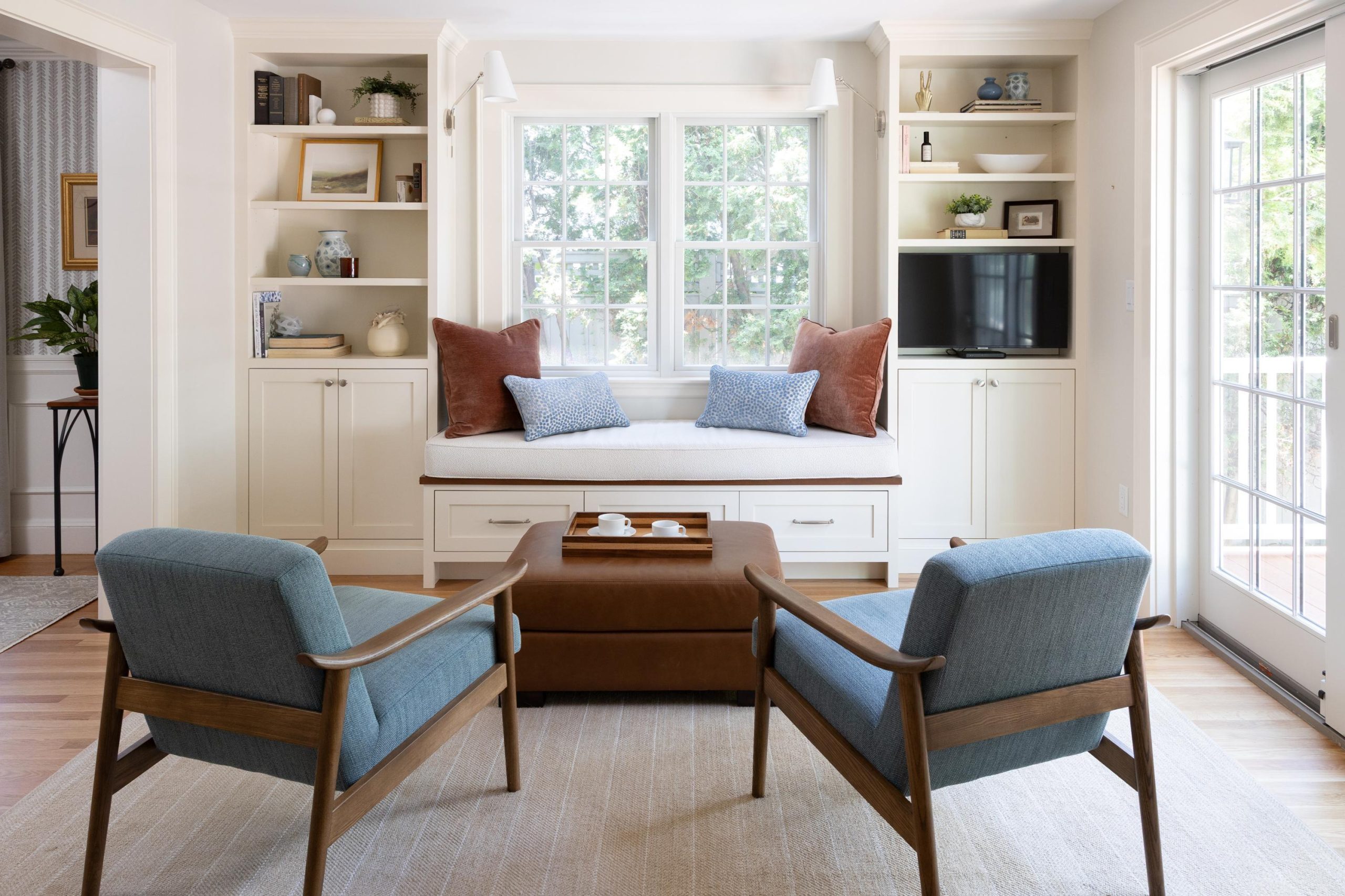 View of spacious window seating and built in storage with exit to deck beyond in Boston, MA