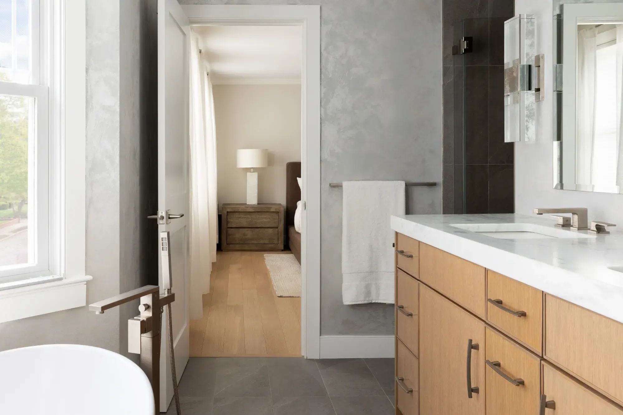 View from newly remodeled primary bath with soaker tub into bedroom beyond