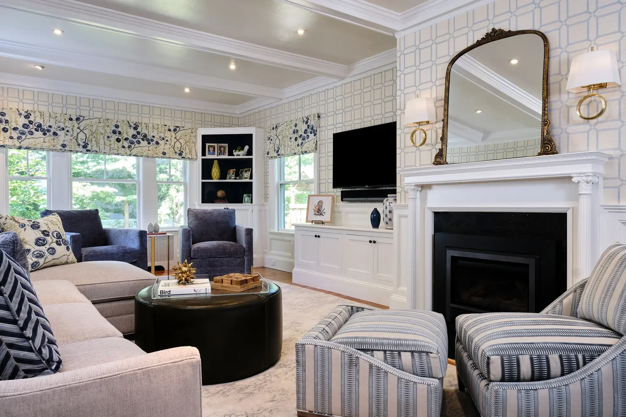 Elegant living room in Greater Boston with fireplace, patterned wallpaper, built-ins, and blue accent chairs